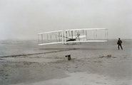 A Wright Flyer első repülése (Orville a pilóta, Wilbur a szárny mellett)