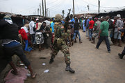 Karantén alá helyezett tömeget oszlató katona Libériában, 2014. augusztus (kép forrása: time.com)