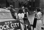 Egy taxi tetején osztogatja Elvis az autogrammokat fiatal rajongóknak, miután befejezték a lemezfelvételi munkákat Nashville-ben 1956-ban